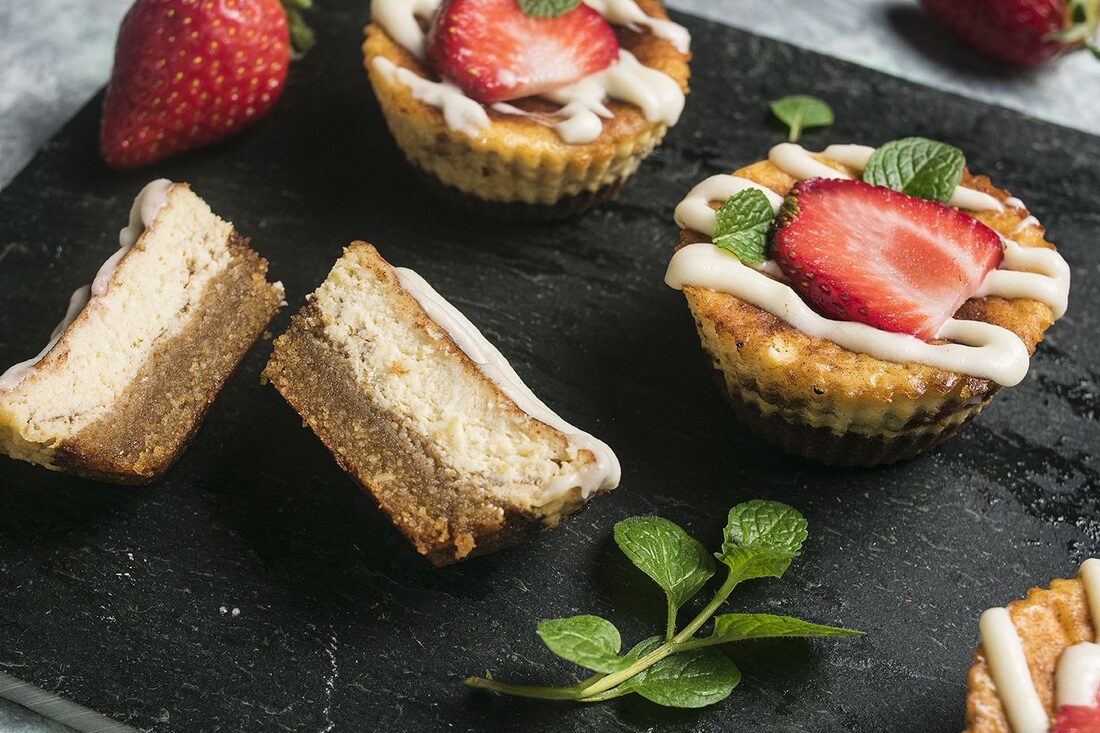 Styled final hero shot of mini cinnamon roll cheesecakes on slate